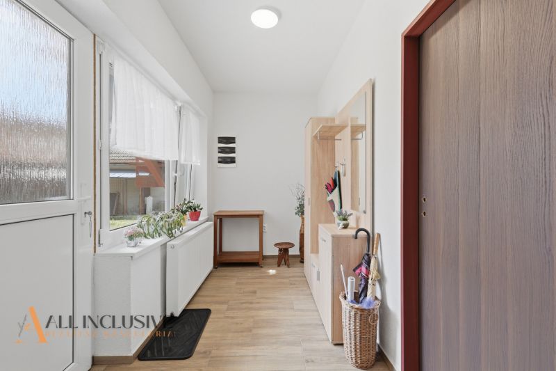 Hallway of a family house with a wooden decor floor, bright entrance hall with furniture.