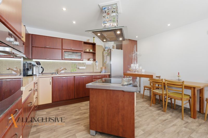 A kitchen in a family house with a wooden decor floor and wooden furniture.