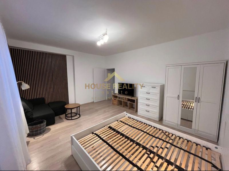 1-bedroom apartment with a bed, sofa, and storage furniture, floor with wood decor.