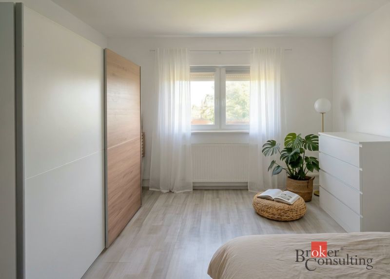 Bright bedroom in a 4-room apartment with minimalist furniture and a wooden decor floor.