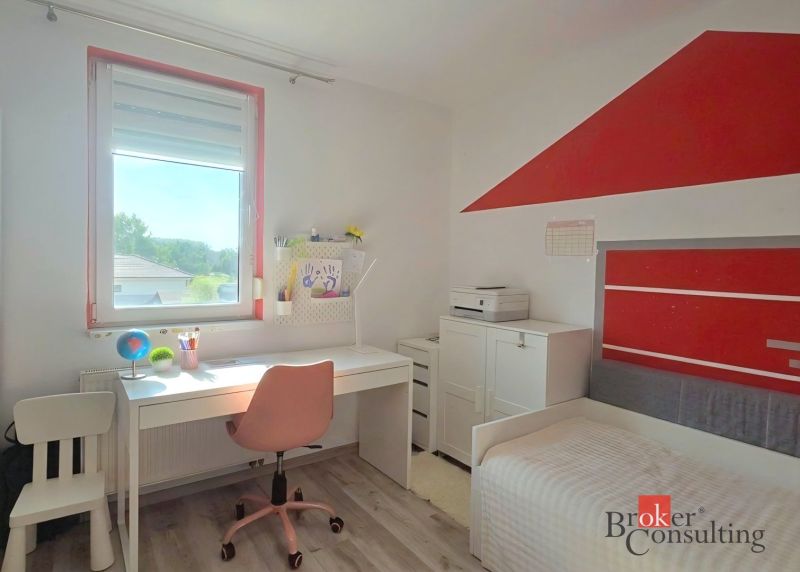 Children's room with a table, chair, bed, and floor with wooden decor in a 4-room apartment.