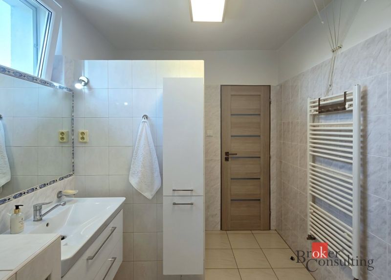 Bathroom in a 4-room apartment with a sink, mirror, and towel radiator.