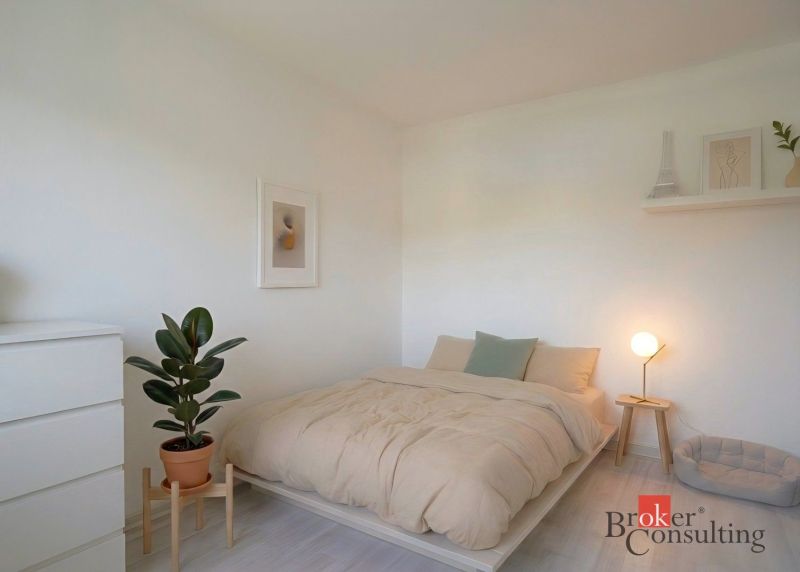 Bedroom in a 4-room apartment with floor decor and a houseplant.