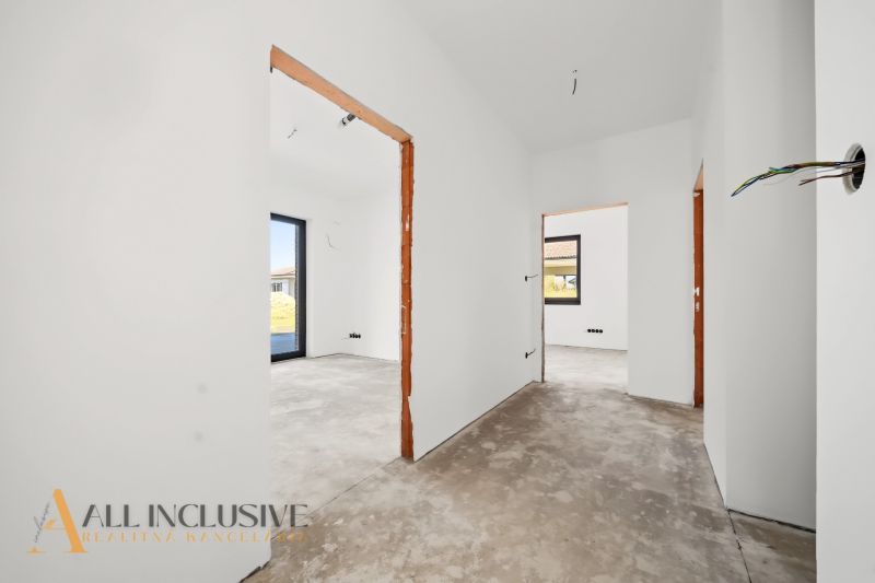 Unplastered interior walls and rough floor, rooms with a view outside. Family house.