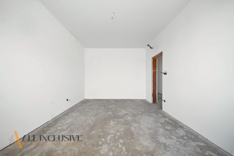 Empty room with a concrete floor and white walls in a family house.
