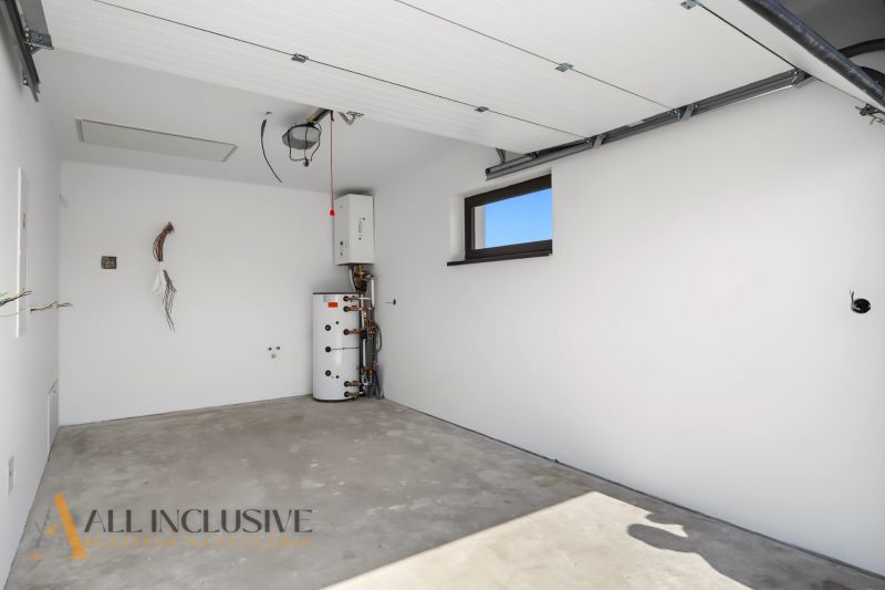 A garage in a family house with a concrete floor and white walls.