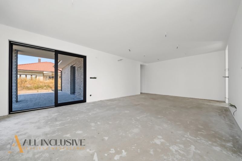 A spacious room in a family house with a concrete floor, view of the terrace.
