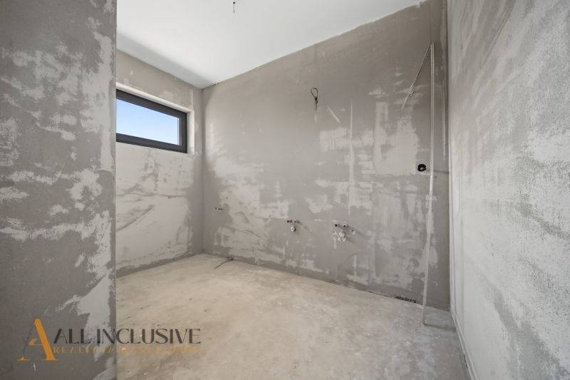 Unfinished room in a family house with smooth walls and a window.