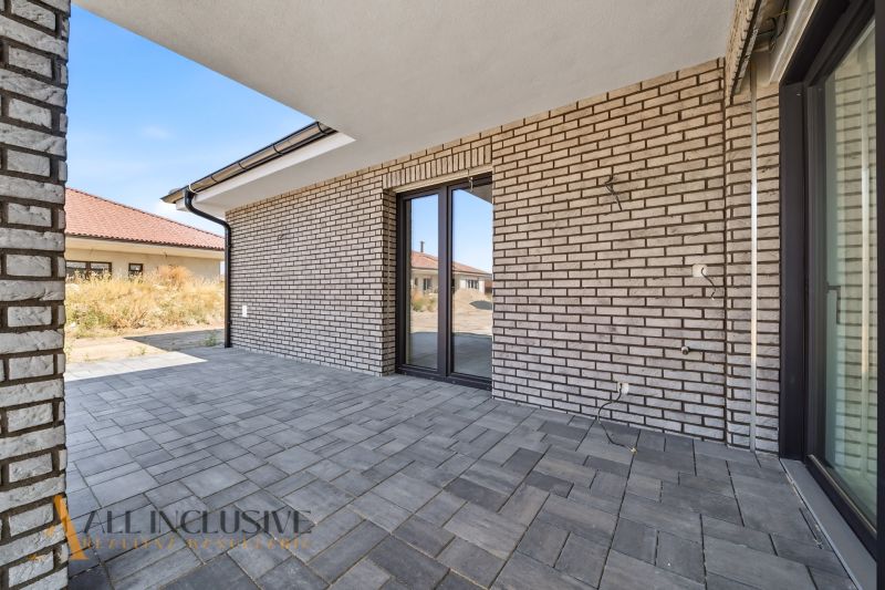 Outdoor terrace of a family house in Hviezdoslavov with a brick wall and paving.