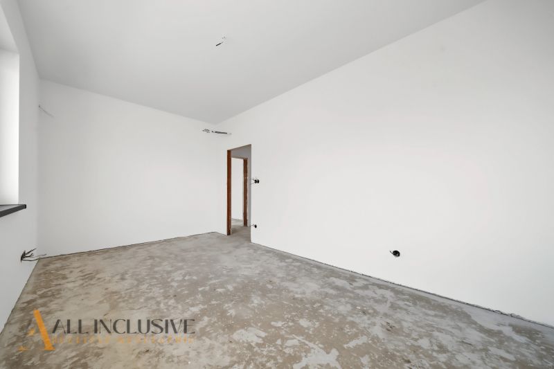 An empty room in a family house without flooring, white walls, construction phase.