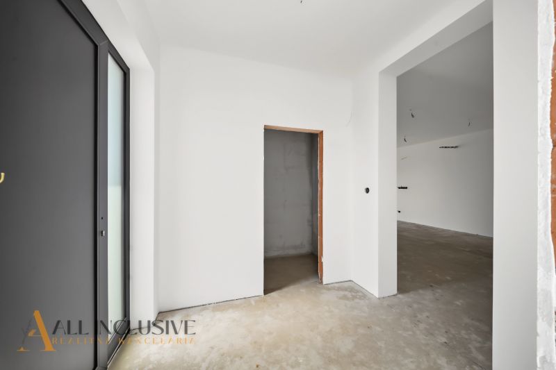 Interior of a family house with white walls and undecorated floor.