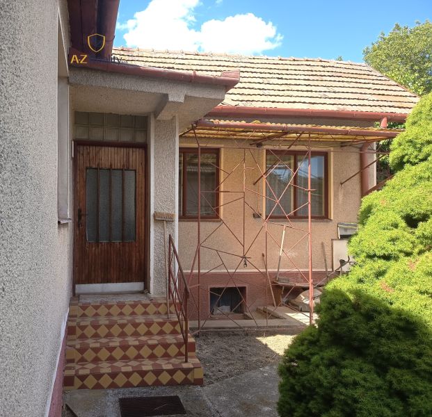 A family house in Bánov with a staircase leading to wooden doors on the property.
