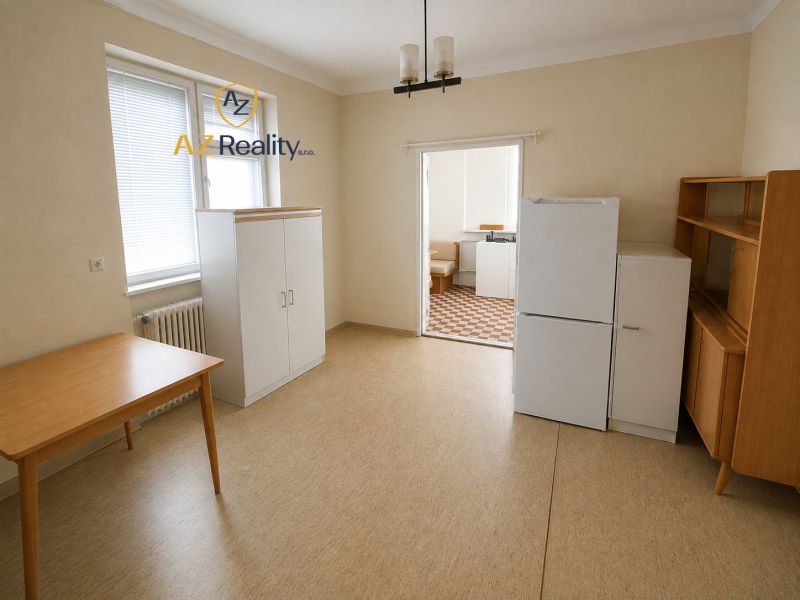 A room with a wooden table, a wardrobe, and a refrigerator in a family house.