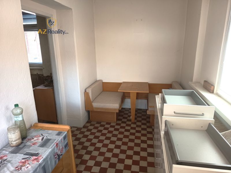 A kitchen in a family house with seating and checkered flooring.
