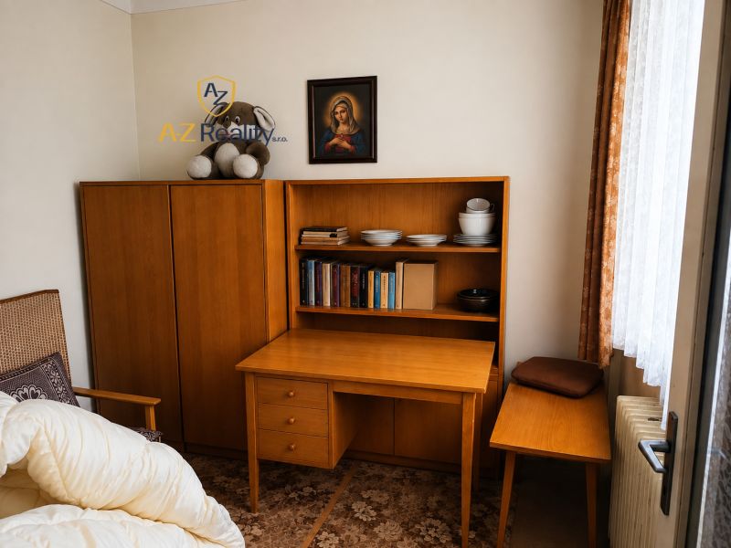 A room in a family house with wooden furniture, books, and decorative items.