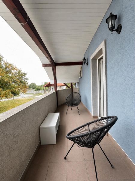 A balcony with black chairs and a blue wall in a 2-room apartment in Horný Bar.