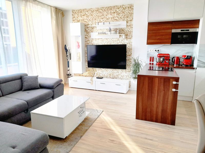 Living room in a 3-room apartment with a wooden decor floor and a sofa set.