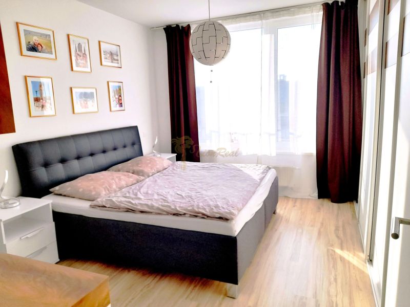 Bright bedroom with wood-decor flooring and decorative paintings, 3-room apartment.
