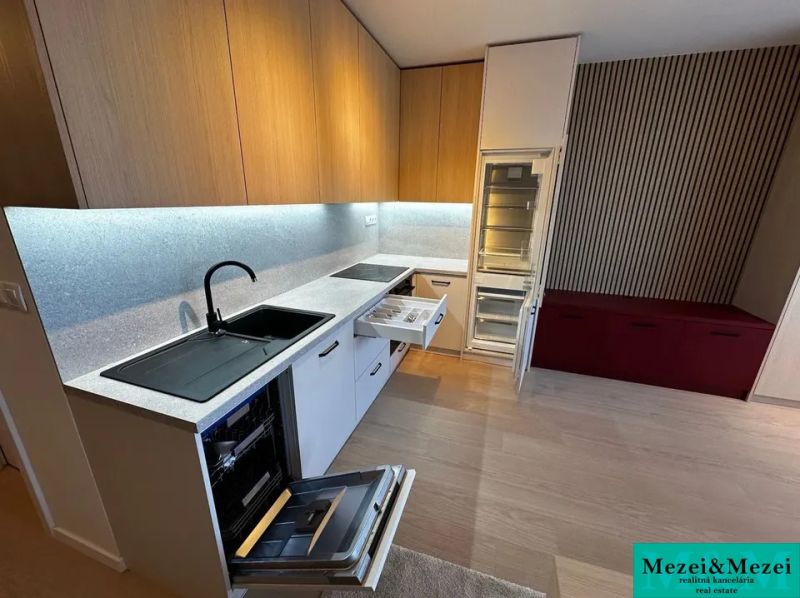 Kitchen unit with open appliances in a studio apartment with a wooden decor floor.
