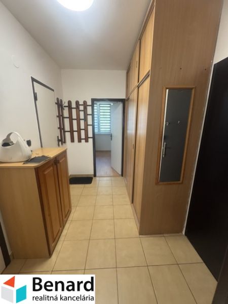 A hallway with storage cabinets and tiles in a 2-room apartment.