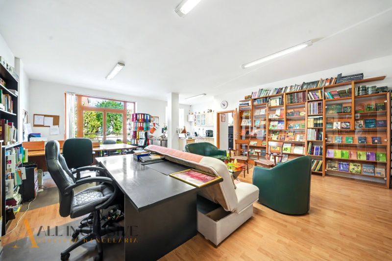 A work office with a library and a wooden decor floor in a 3-room apartment.