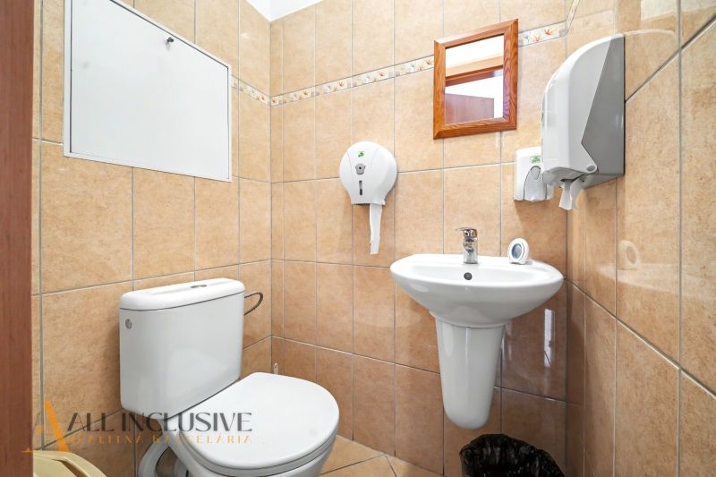 Bathroom with a toilet in a 3-room apartment, tiled with light tiles.