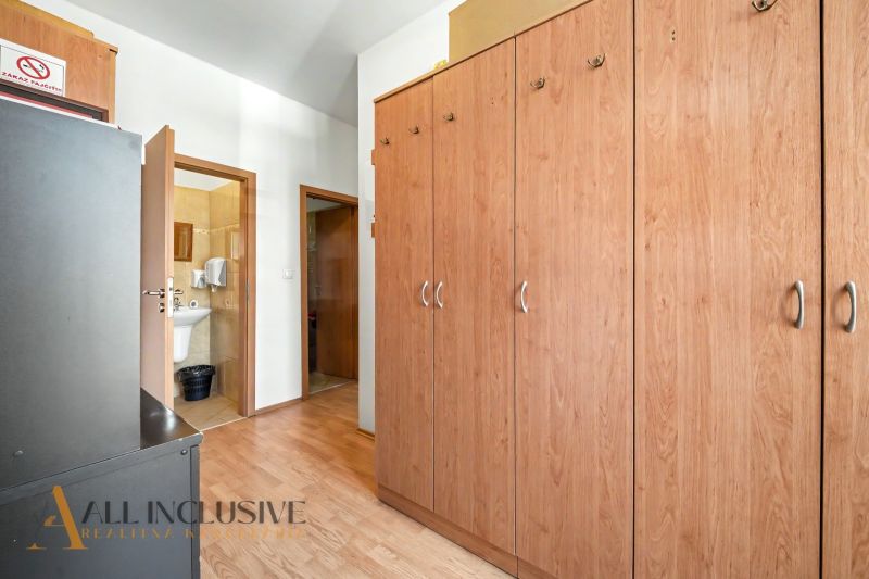 A hallway with a wooden decor floor, wardrobes, and a bathroom in a 3-room apartment.