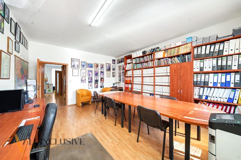 Office space with archive, wooden decor flooring, large table, chairs.