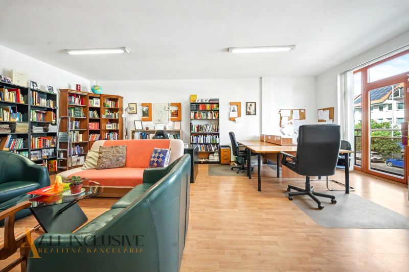 Library with comfortable seating and writing desks on a floor with wooden decor.