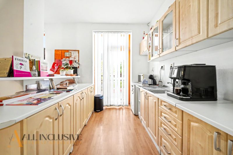 A kitchen in a 3-room apartment with a wooden decor floor and a kitchen unit.