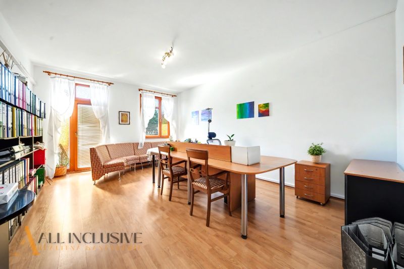 A bright living room with wood-patterned flooring, armchairs, and a desk in a 3-room apartment.
