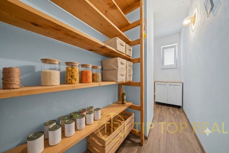 Pantry with shelves and groceries in a family house, floor with wooden decor.