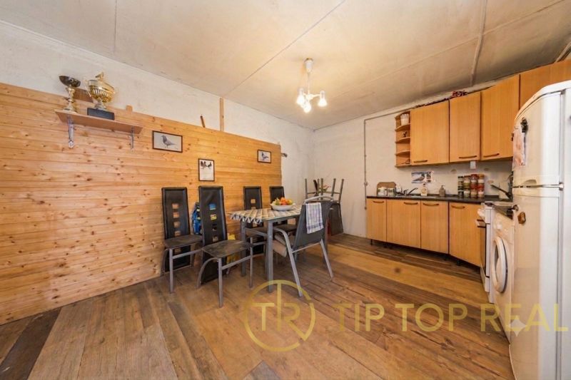 A kitchen in a family house with wooden paneling and a floor with a wooden decor.