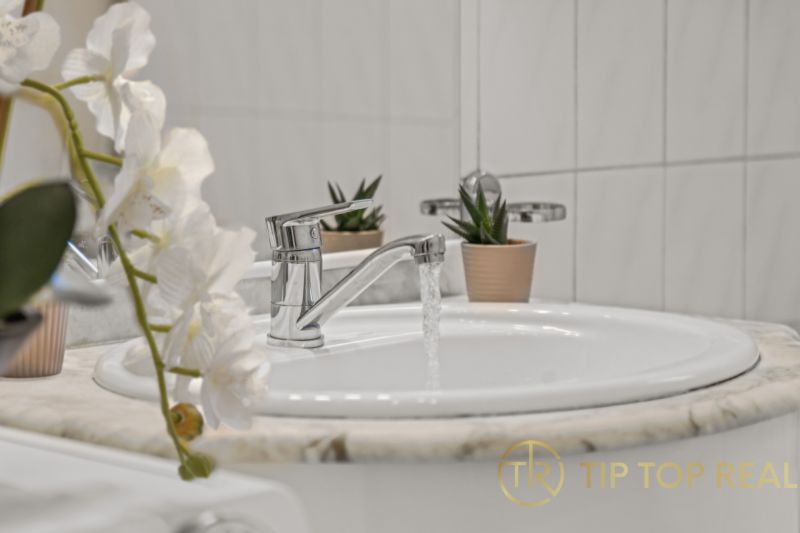 A sink with running water and decoration in a family house.