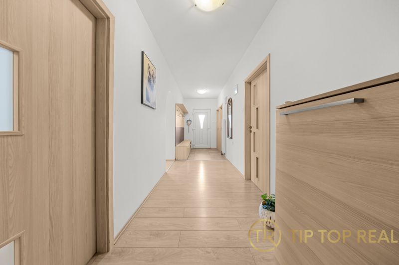 A hallway in a family house with a wooden decor floor and built-in furniture.
