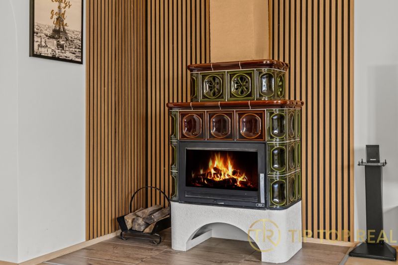 Tiled stove in the interior of a family house with a wooden decor floor.