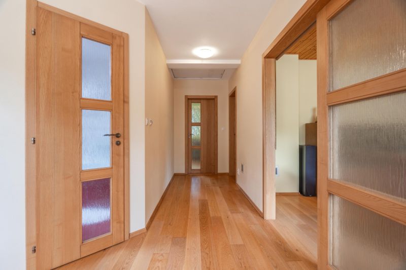 Hallway in a family house with doors and a floor with a wooden decor.