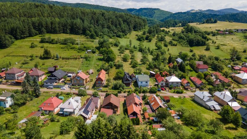 Family houses in Horná Lehota surrounded by green hills and dense forests.