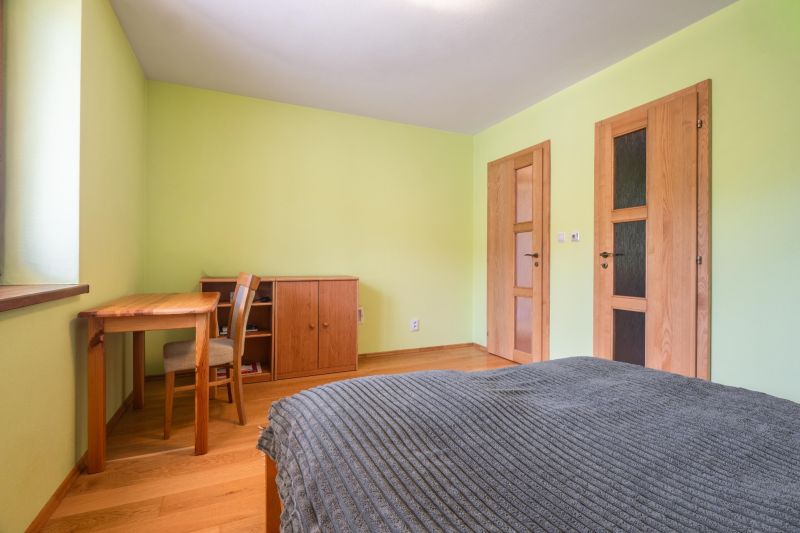 Bedroom in a family house with wooden furniture and a floor with a wooden decor.