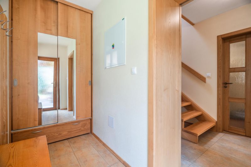 A hallway in a family house with wooden decor and a wardrobe.