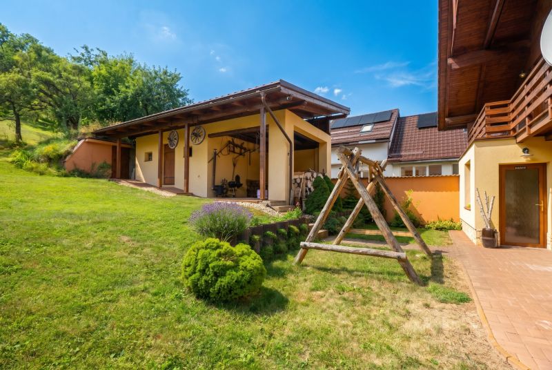 A family house in Horná Lehota with a wooden shelter and a large grassy yard.