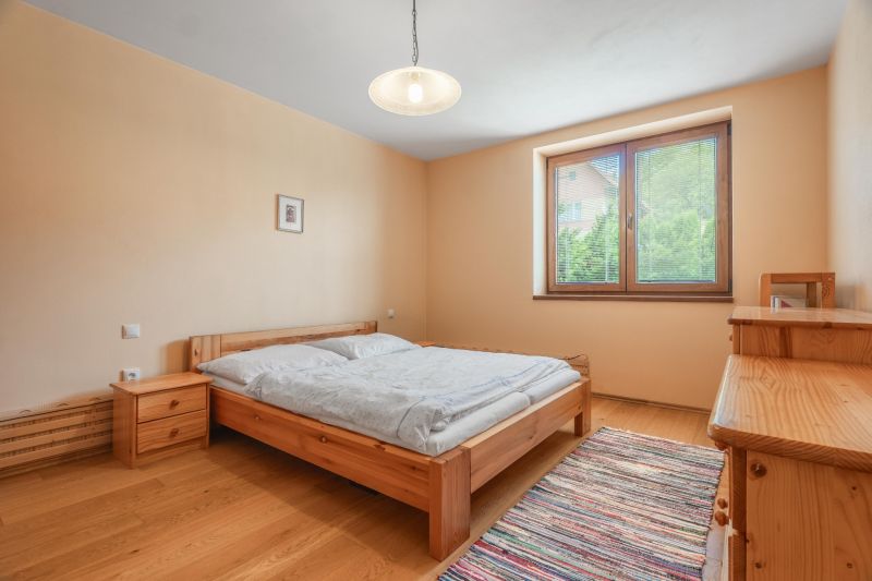 A bedroom with wooden furniture and a wooden decor floor in a family house.