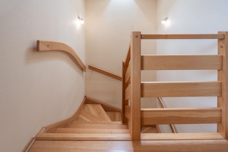 A staircase with a wooden railing and a floor with a wooden decor in a family house.
