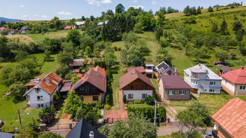 Family houses in Horná Lehota surrounded by greenery and hilly terrain.