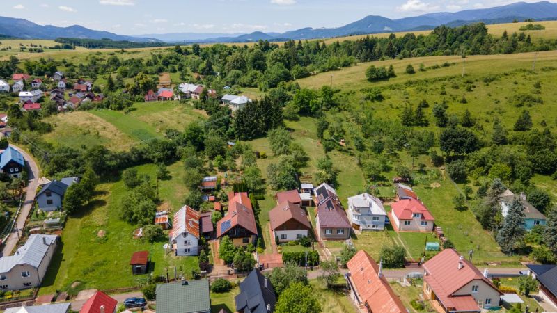 A view of family houses in Horná Lehota with hilly landscape in the background.