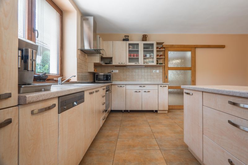 Kitchen in a family house with wooden decor, equipped with furniture and appliances.