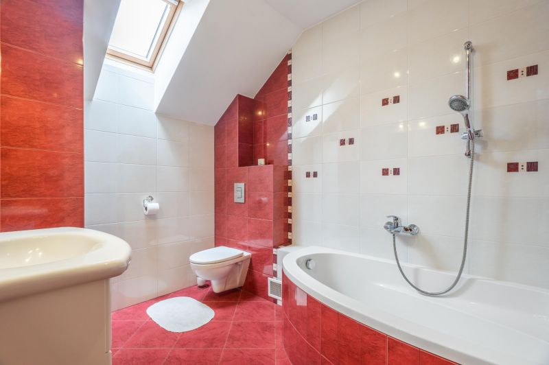 A bathroom in a family house with red and white ceramic tiles, a bathtub, and a window.
