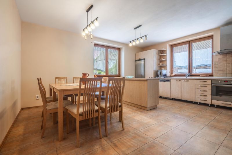 A kitchen in a family house with a dining table, wooden decor, and modern appliances.
