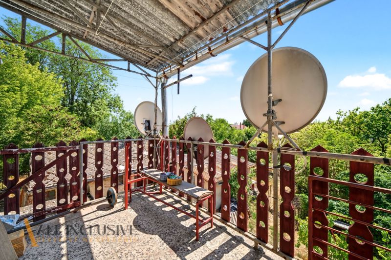 A balcony of a family house in Bodza with satellites and greenery in the background.