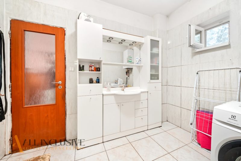 A bathroom in a family house with white furniture and a washing machine.